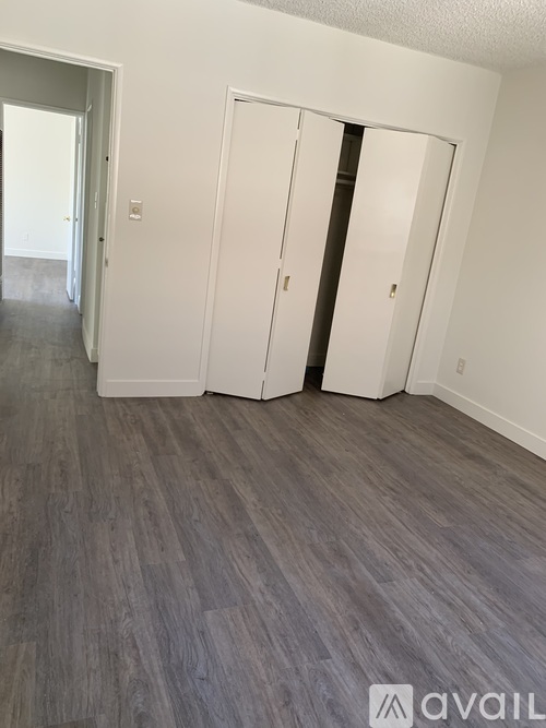 A room with two white doors and a grey floor.