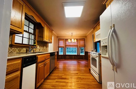 A kitchen with wooden cabinets and a white refrigerator.