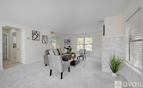A living room with a grey couch and a white rug.