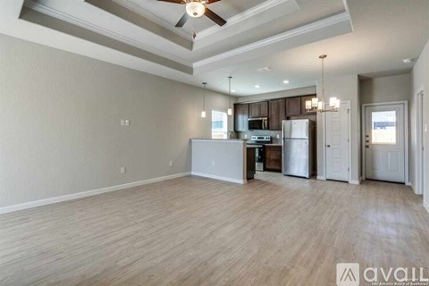 A spacious kitchen with a ceiling fan and lighting fixtures.