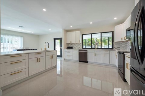 A modern kitchen with white cabinets and a large island.
