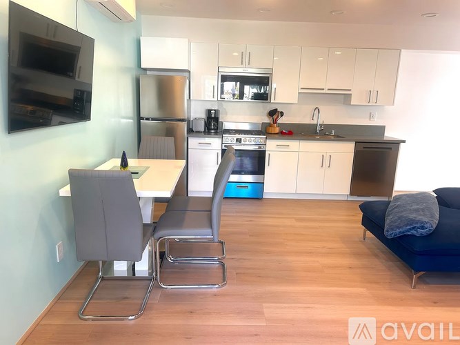 A modern kitchen with a dining table and chairs.