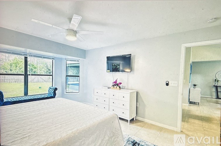 A bedroom with a bed, dresser, and window.