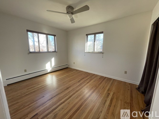 A room with wooden flooring and a ceiling fan.