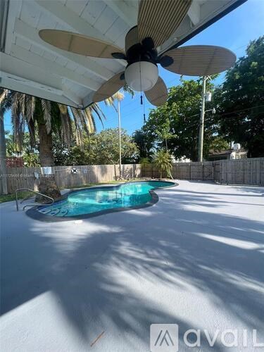 A pool under a white canopy with a ceiling fan.