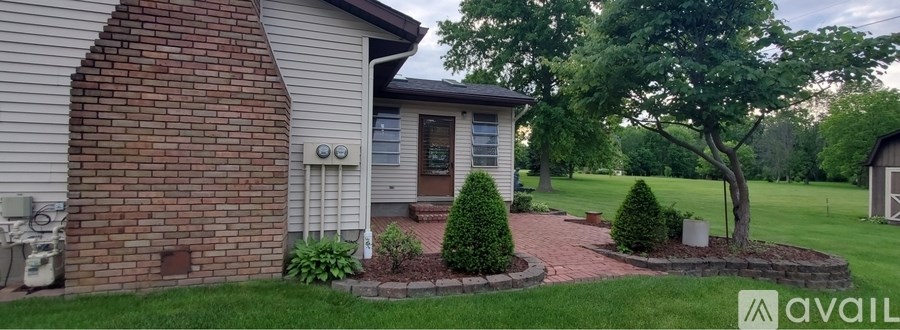 A house with a brick chimney and a small garden in front.