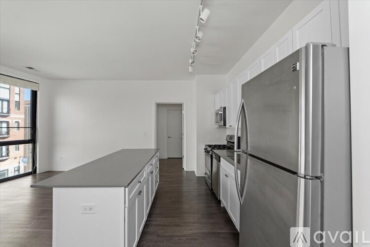 A modern kitchen with stainless steel appliances and white cabinets.