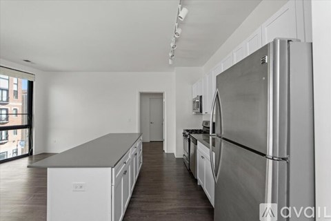A modern kitchen with stainless steel appliances and white cabinets.