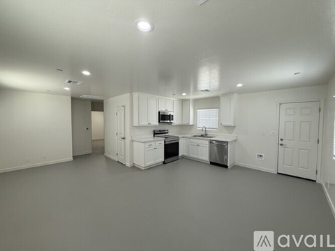 A spacious kitchen with white cabinets and appliances is available for rent.