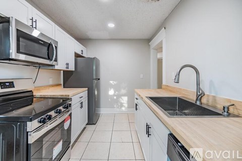 A kitchen with a black stove top oven and a black microwave above it.