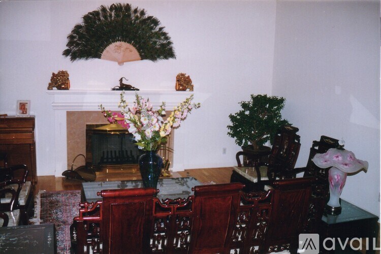 A room with a fireplace and a vase of flowers.