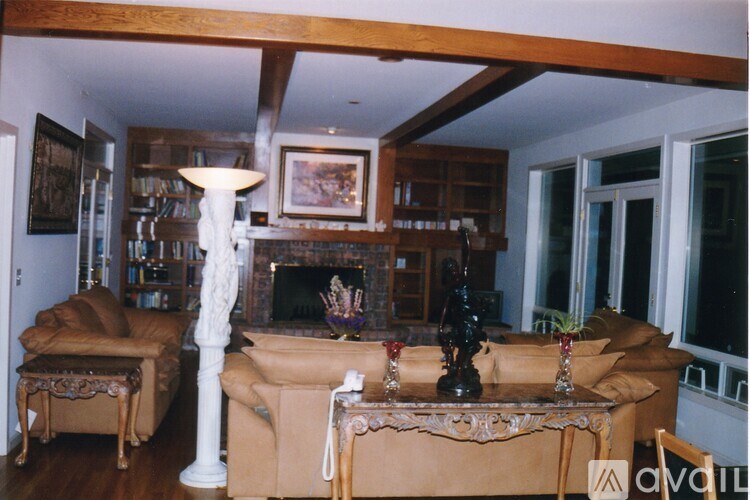 A living room with a couch, chair, and fireplace.