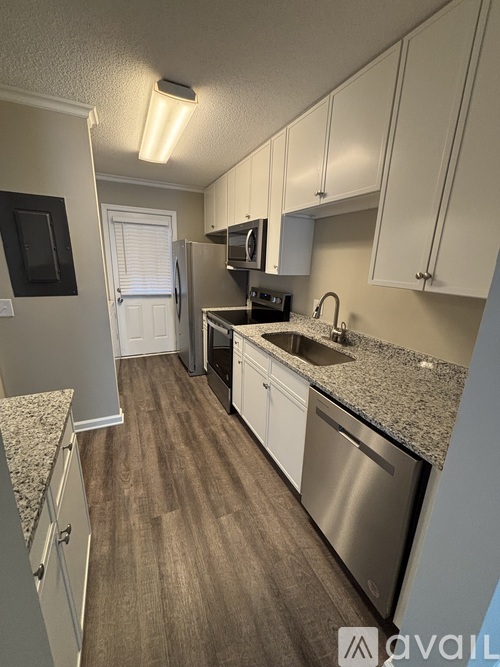 A kitchen with white cabinets and a granite countertop.