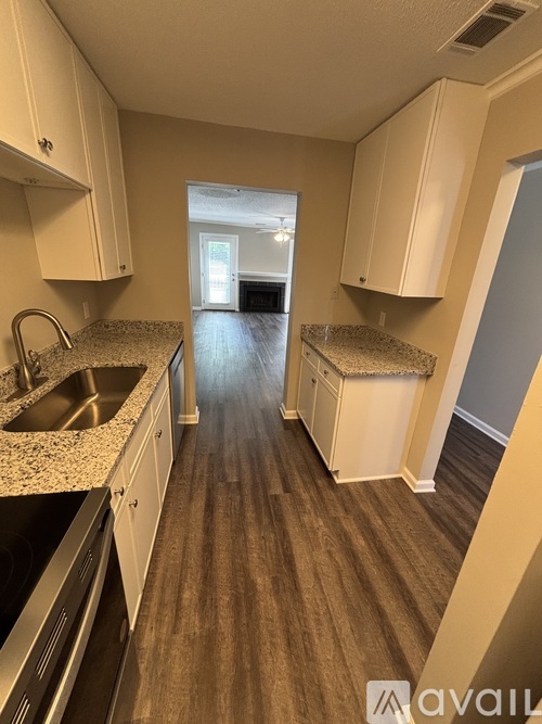 A kitchen with white cabinets and a sink.