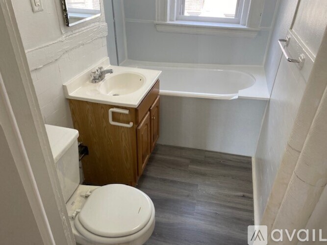A bathroom with a toilet, sink, and bathtub.