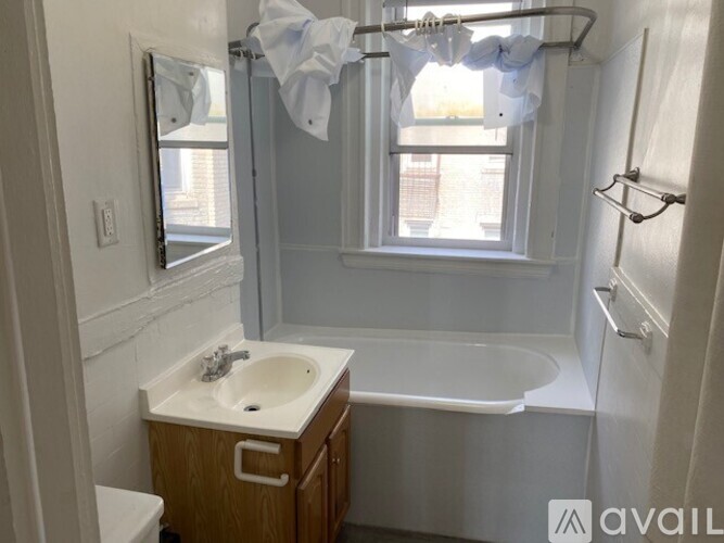 A bathroom with a white sink and a window.
