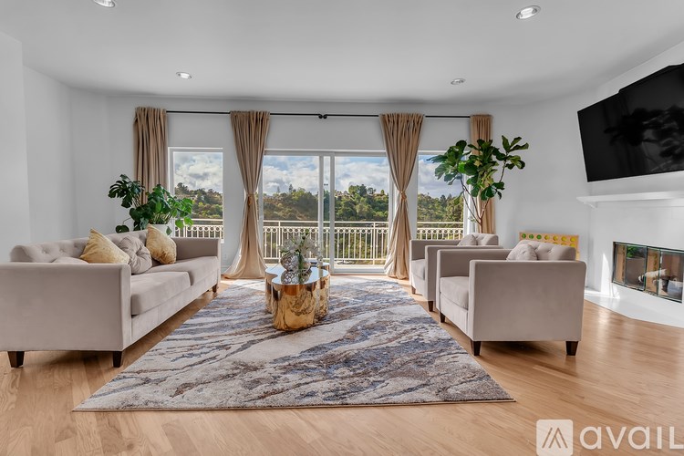 A living room with a large rug, two couches, and a television.