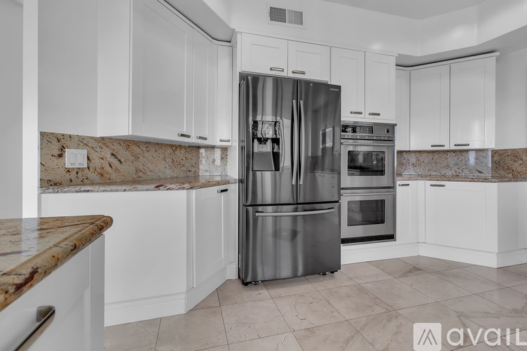 A kitchen with a granite countertop and stainless steel appliances.
