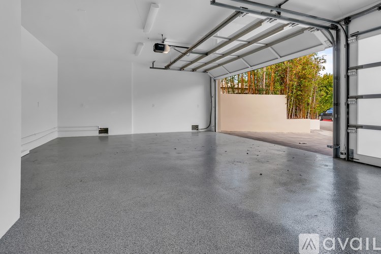A spacious garage with a concrete floor and white walls.