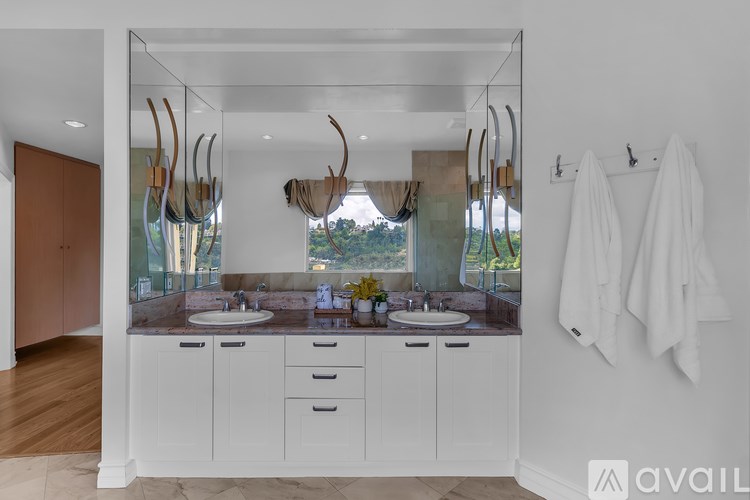 A bathroom with two sinks and a large mirror.