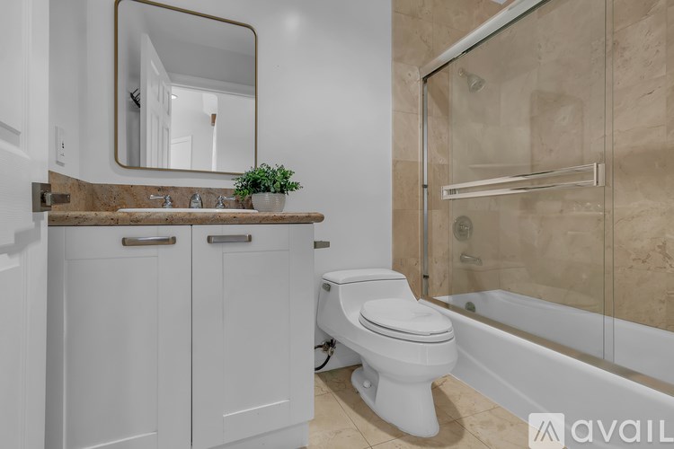 A bathroom with a toilet, sink, and mirror.