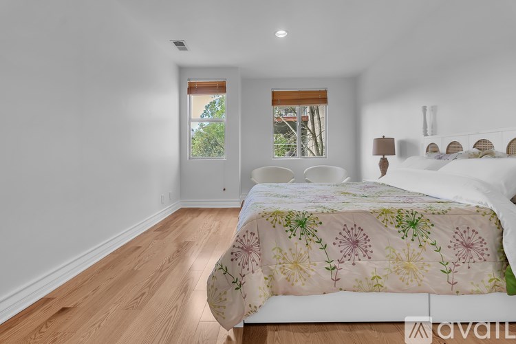 A bedroom with a large bed and a window with a view of trees.