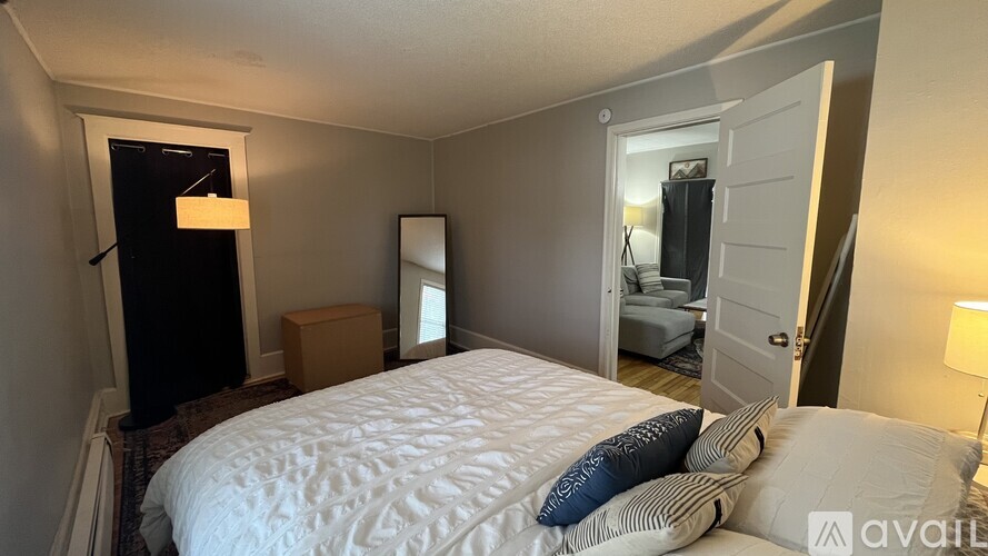 A bedroom with a large bed and a dresser with a mirror.