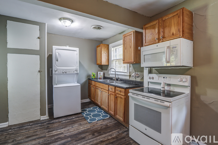A kitchen with a white stove top oven and a white refrigerator.
