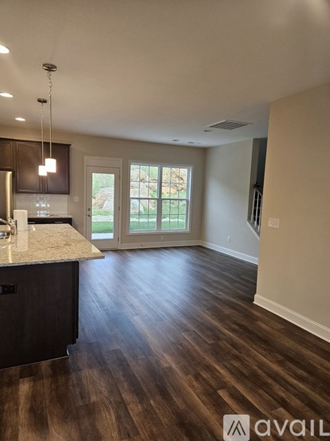 A kitchen with dark wood floors and a large island.
