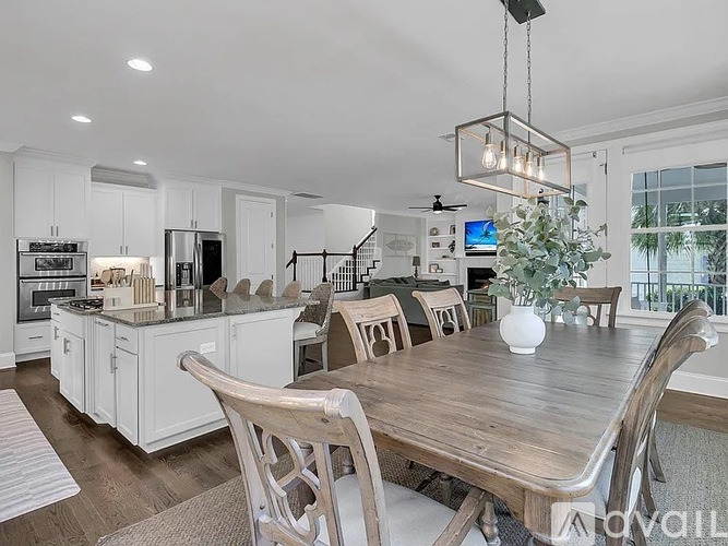 A modern kitchen with a wooden dining table and chairs.