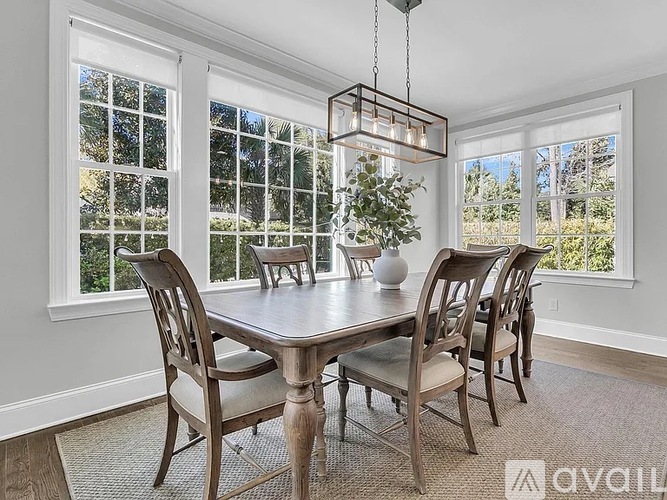 A dining room with a table and chairs.