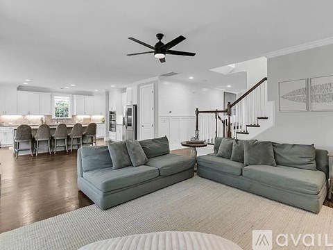 A living room with a grey couch and a ceiling fan.