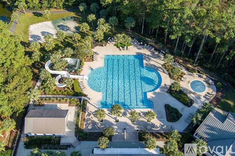 An aerial view of a swimming pool surrounded by trees and buildings.