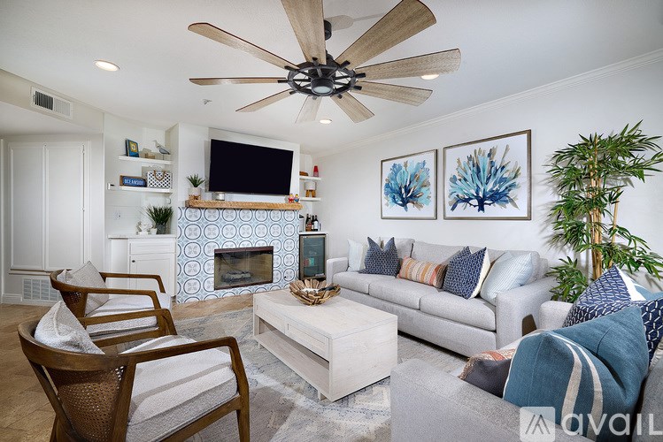 A living room with a fireplace and a TV on the wall.