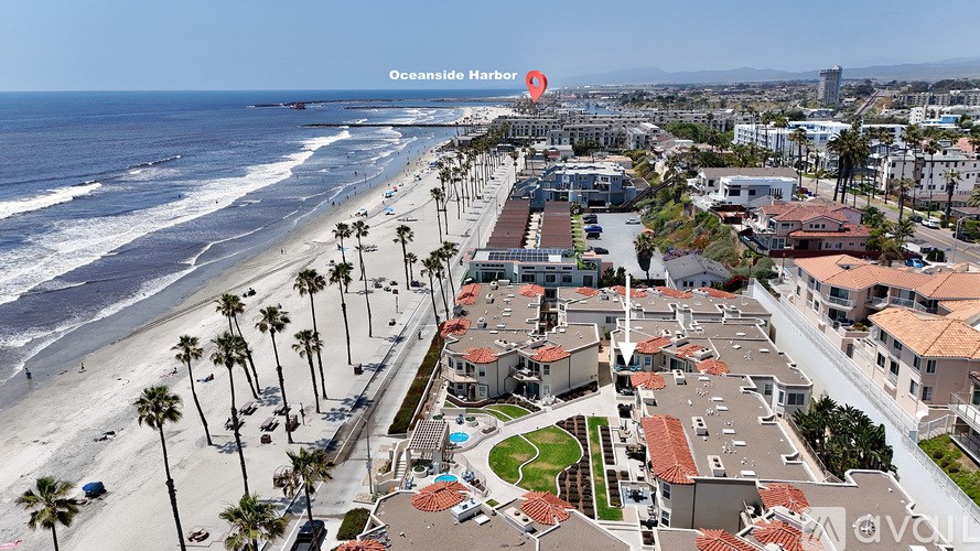 An aerial view of a beachfront property with a red marker indicating the Oceanside Harbor.