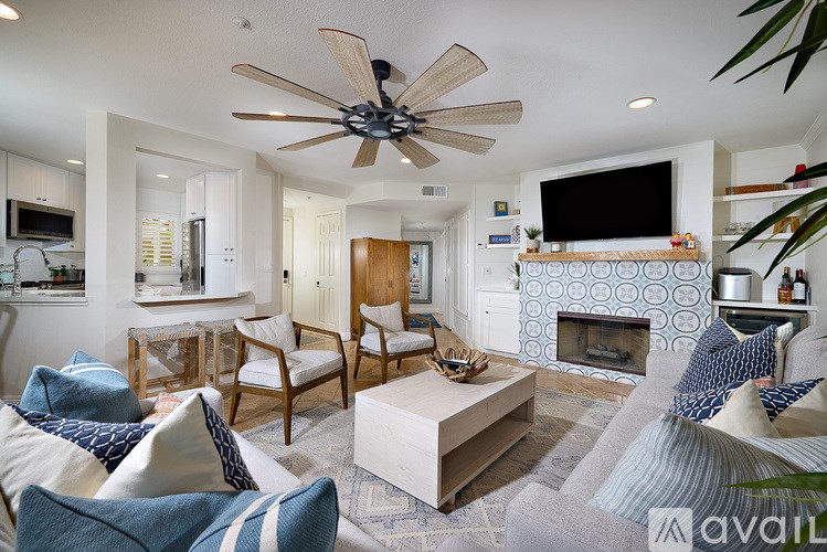 A living room with a fireplace and a television on the wall.