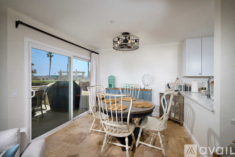 A dining room with a table set for two and a view of the outside.