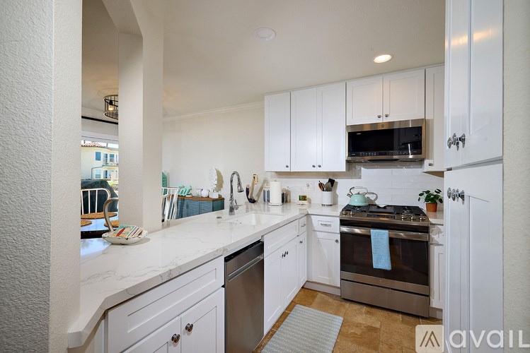 A kitchen with white cabinets and a stainless steel oven.