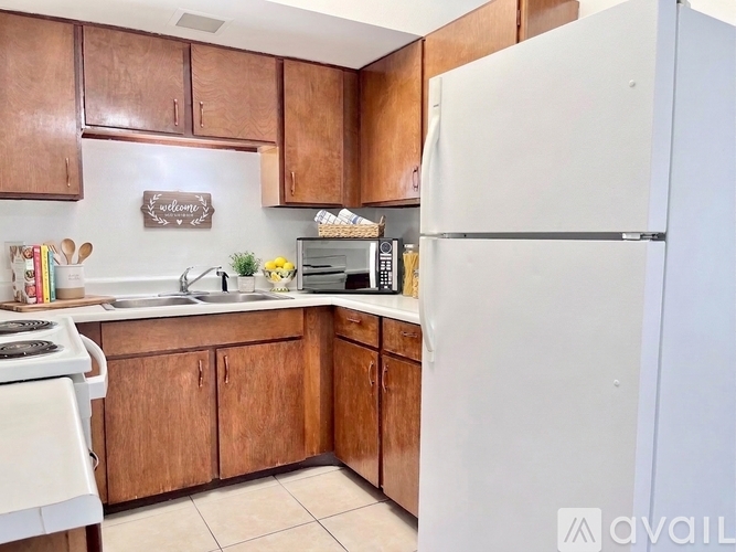 A kitchen with brown cabinets and a white refrigerator.