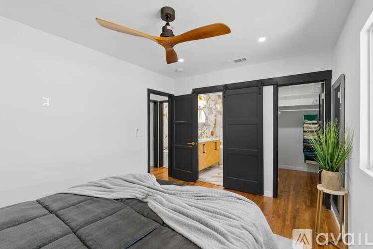 A bedroom with a bed and a ceiling fan.