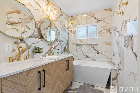 A bathroom with marble walls and a wooden vanity.