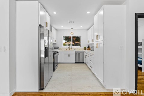 A modern kitchen with white cabinets and a marble floor.