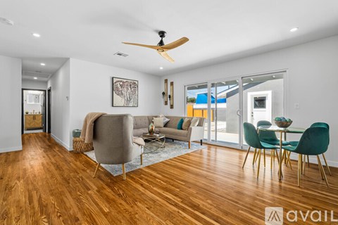 A living room with a grey sofa, a green chair, and a wooden floor.
