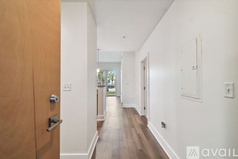 A long hallway with a wooden floor and white walls.