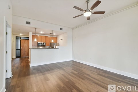 A spacious room with a ceiling fan and wooden flooring.