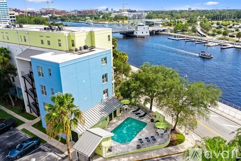 A blue and green building with a pool in front.