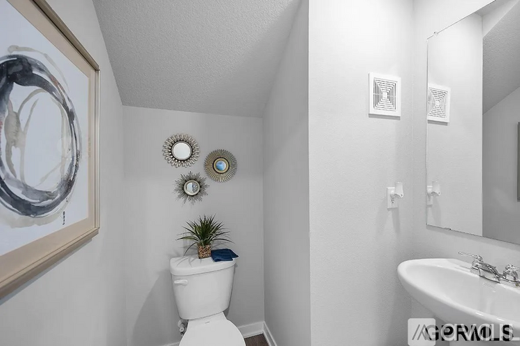 A white toilet sits in a bathroom next to a sink.