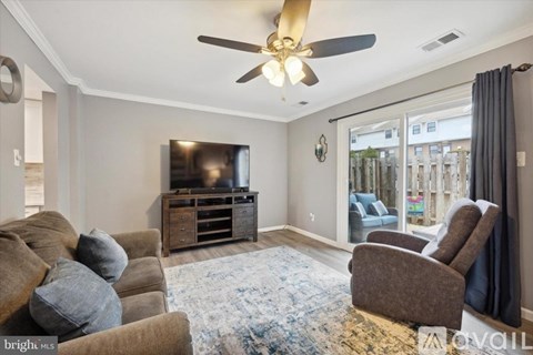 A living room with a brown couch and a flat screen TV.