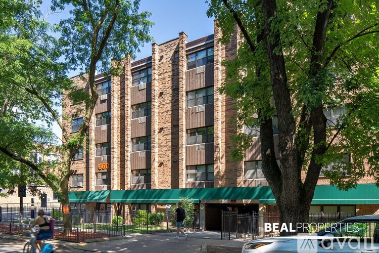 A large brick building with a green awning and the words "Beal Properties" on it.