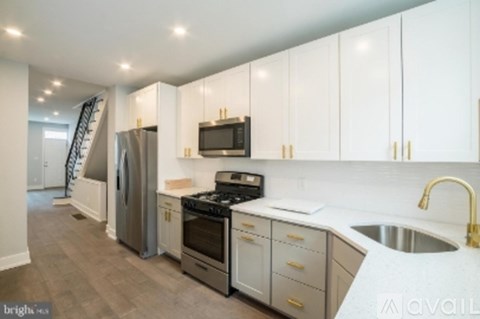 A kitchen with white cabinets and a stainless steel refrigerator.